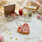 Heart-shaped pizza with jewelry on a decorative table setting with candles and flowers.