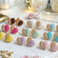 Heart-shaped cookies with colorful icing on a decorative surface with flowers and jewelry.