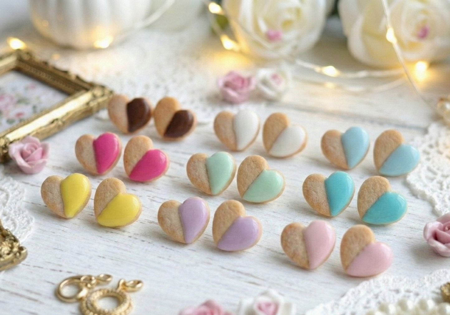 Heart-shaped cookies with colorful icing on a decorative surface with flowers and jewelry.