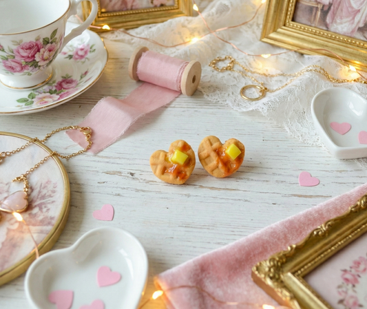 waffle studs in a Decorative setting with teacup, heart-shaped plates, and small pastries on a wooden surface.